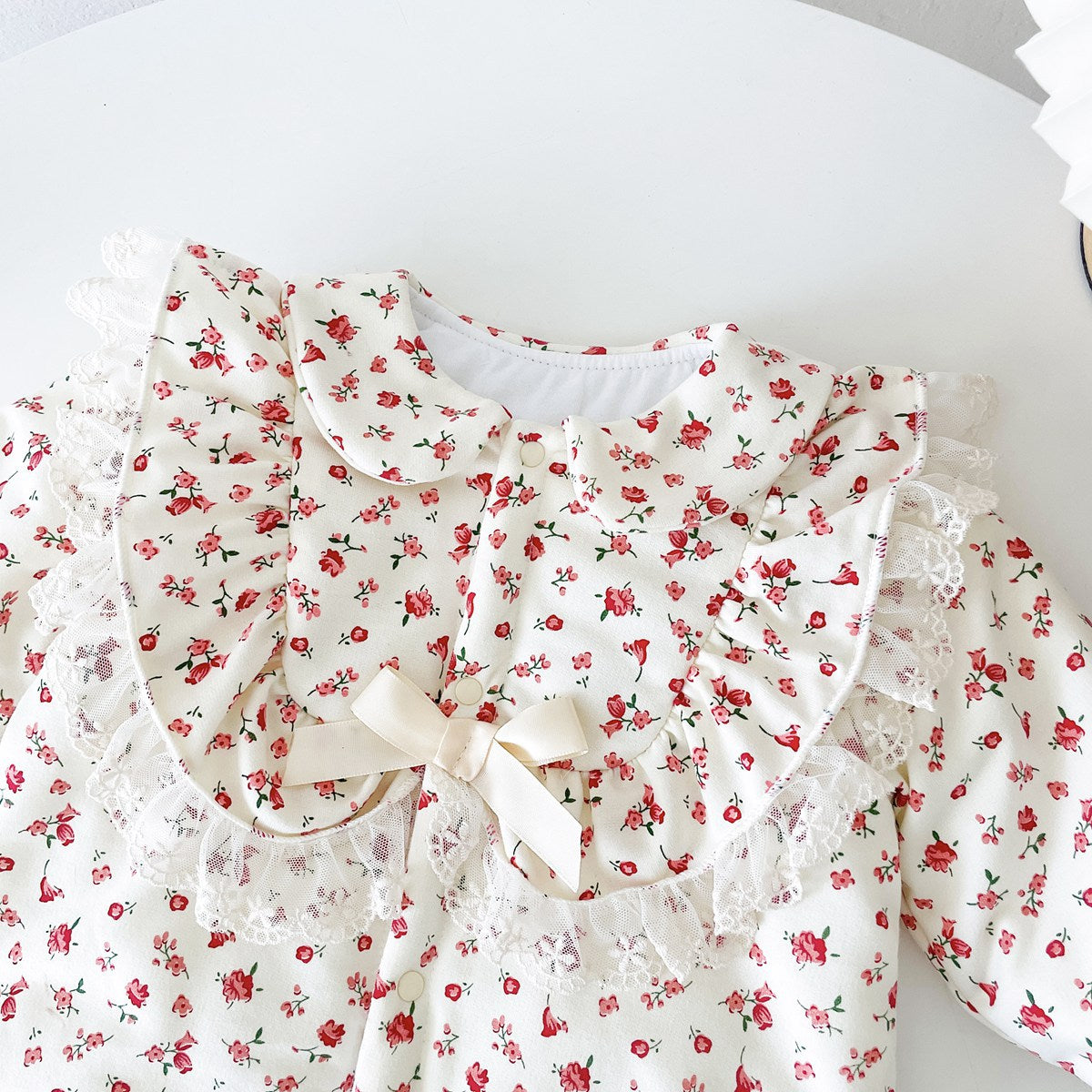 Baby girl romper featuring a ditsy flower pattern and mesh patches, designed for comfort and style.
