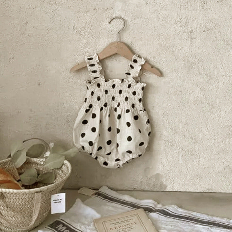 Baby girl wearing a beige and apricot polka dot sling onesie and dress, perfect for summer outings.