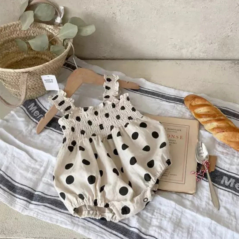 Baby girl wearing a beige and apricot polka dot sling onesie and dress, perfect for summer outings.
