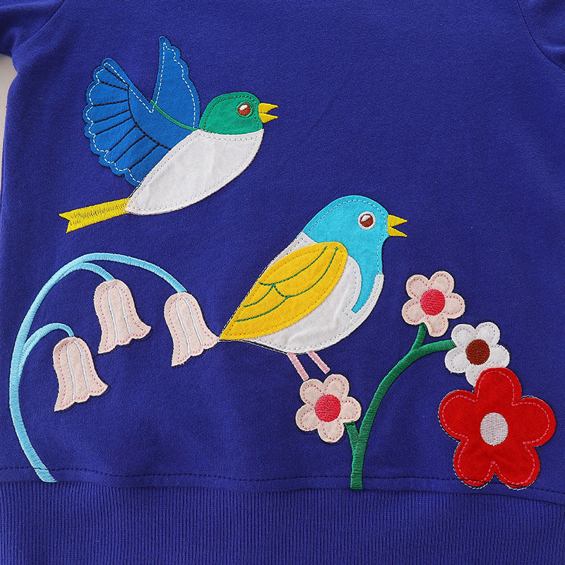 Baby girl wearing a blue embroidered pattern long sleeve cotton hoodie with floral and cartoon designs.