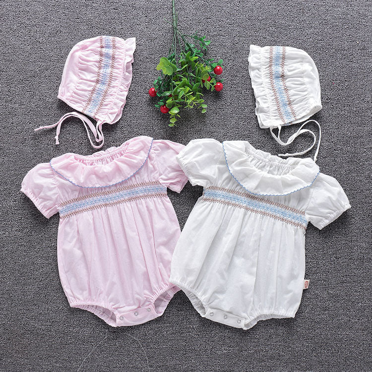 Baby girl wearing an embroidered bubble onesie with a ruffle collar in white and pink colors, perfect for summer.