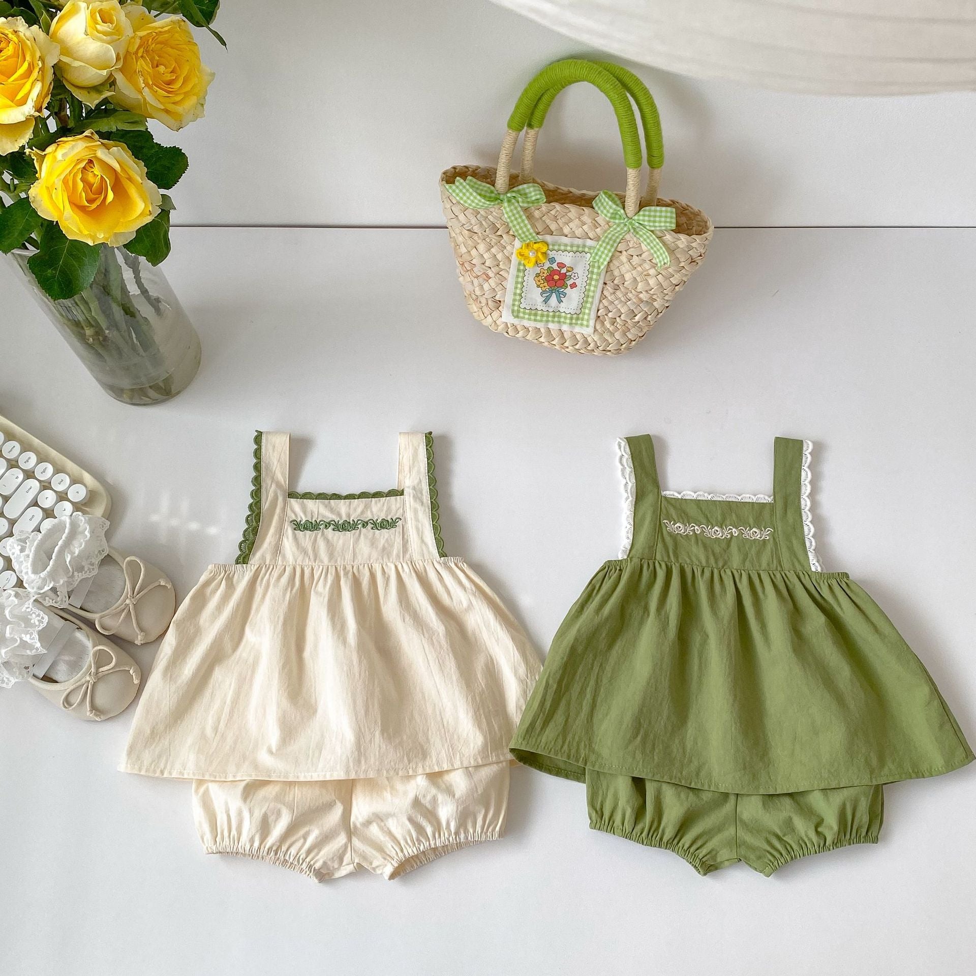 Baby girl wearing a green embroidery pattern sling top with shorts, showcasing floral designs and a comfortable fit.