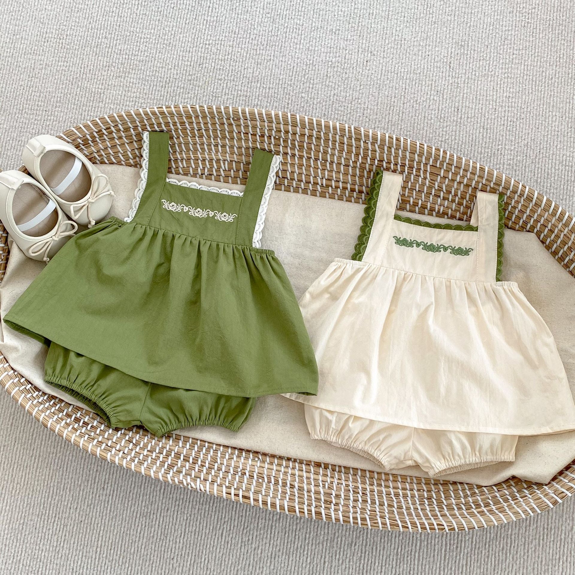 Baby girl wearing a green embroidery pattern sling top with shorts, showcasing floral designs and a comfortable fit.
