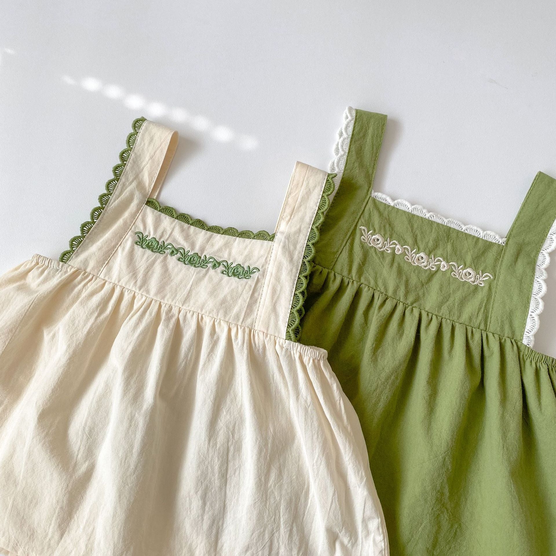 Baby girl wearing a green embroidery pattern sling top with shorts, showcasing floral designs and a comfortable fit.