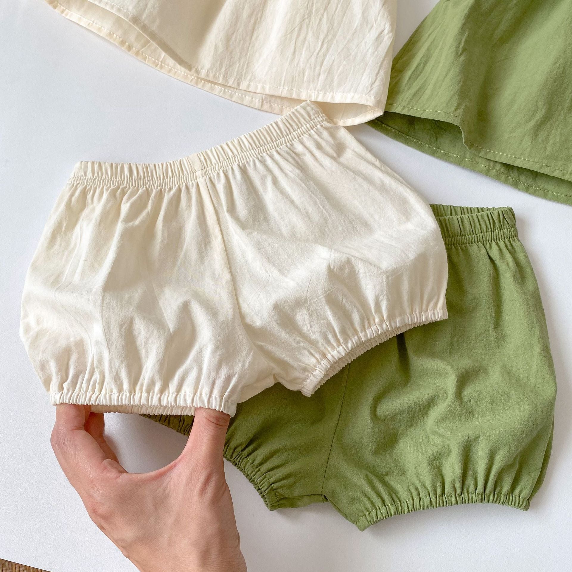 Baby girl wearing a green embroidery pattern sling top with shorts, showcasing floral designs and a comfortable fit.