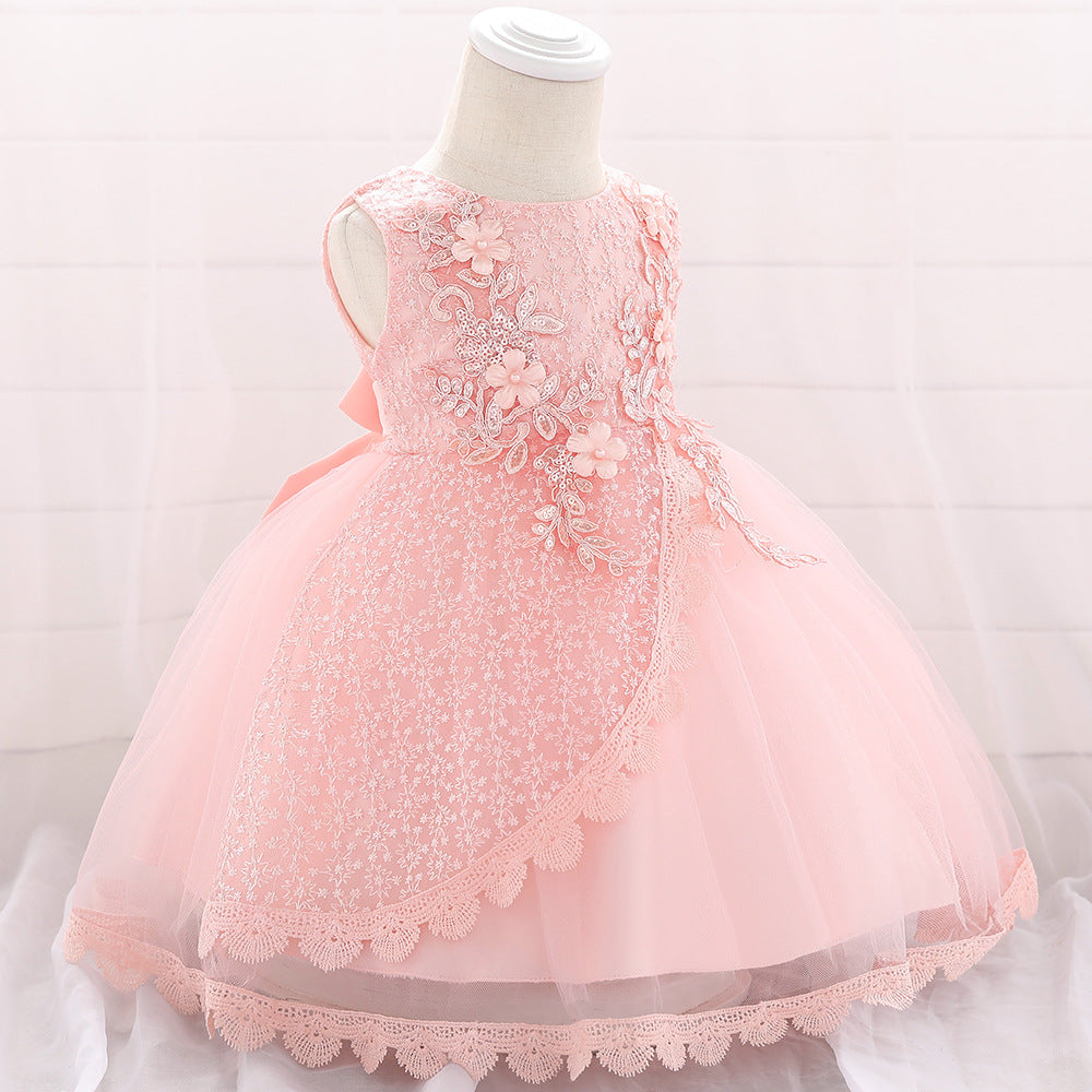 Baby girl wearing a floral embroidered christening dress with sequins and a tutu style, showcasing elegance and charm.