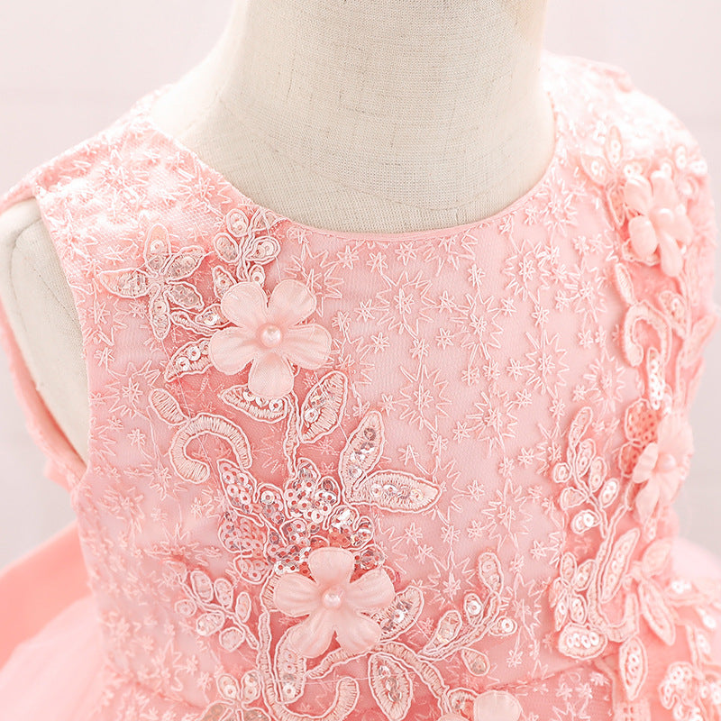 Baby girl wearing a floral embroidered christening dress with sequins and a tutu style, showcasing elegance and charm.