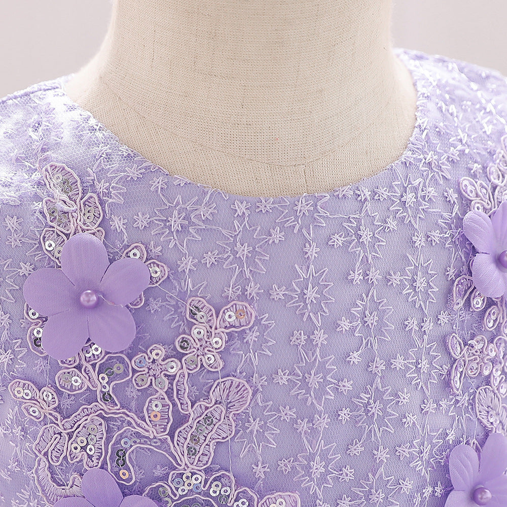 Baby girl wearing a floral embroidered christening dress with sequins and a tutu style, showcasing elegance and charm.