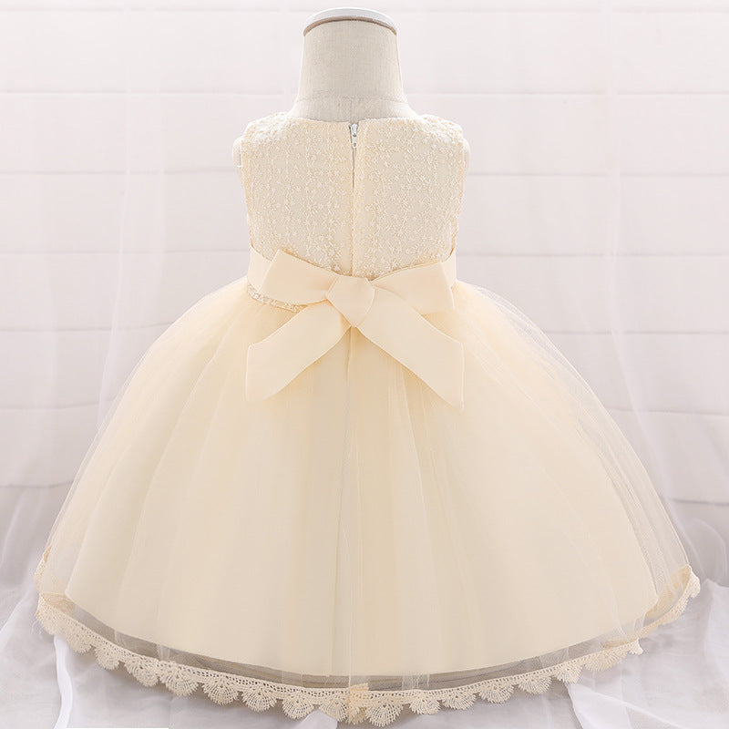 Baby girl wearing a floral embroidered christening dress with sequins and a tutu style, showcasing elegance and charm.