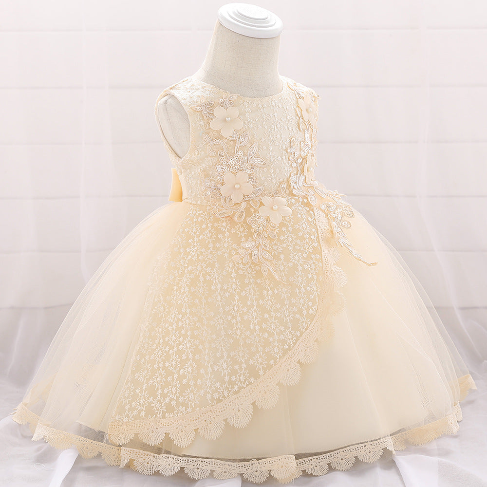 Baby girl wearing a floral embroidered christening dress with sequins and a tutu style, showcasing elegance and charm.