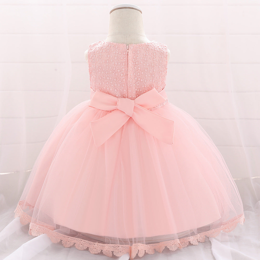 Baby girl wearing a floral embroidered christening dress with sequins and a tutu style, showcasing elegance and charm.