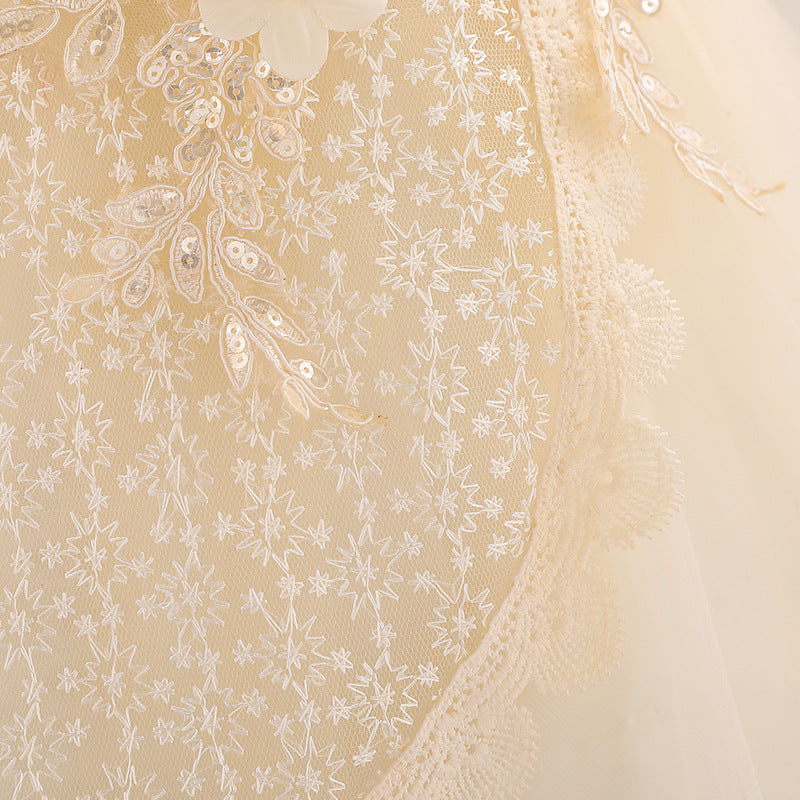 Baby girl wearing a floral embroidered christening dress with sequins and a tutu style, showcasing elegance and charm.