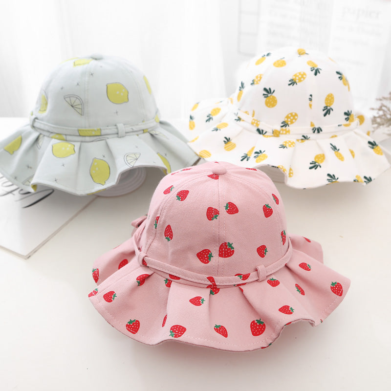 Baby girl wearing a floral print adjustable sunshade bucket hat in various colors, perfect for sun protection.