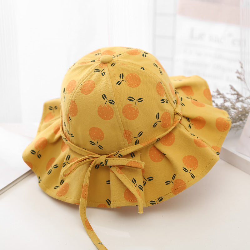 Baby girl wearing a floral print adjustable sunshade bucket hat in various colors, perfect for sun protection.