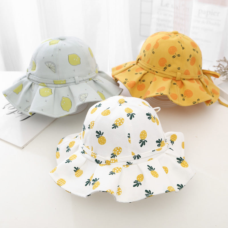 Baby girl wearing a floral print adjustable sunshade bucket hat in various colors, perfect for sun protection.