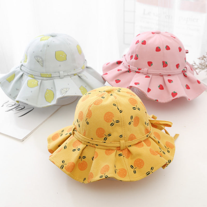 Baby girl wearing a floral print adjustable sunshade bucket hat in various colors, perfect for sun protection.