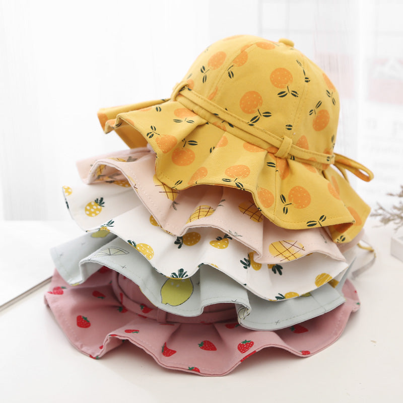Baby girl wearing a floral print adjustable sunshade bucket hat in various colors, perfect for sun protection.