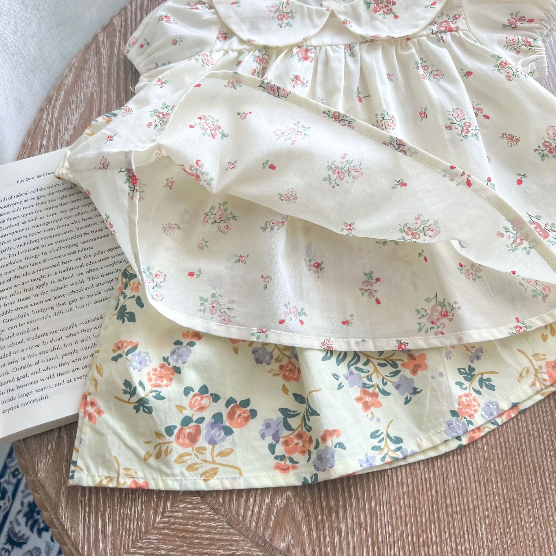 Baby girl wearing a floral print doll collar top and shorts set in white and yellow, perfect for summer outings.