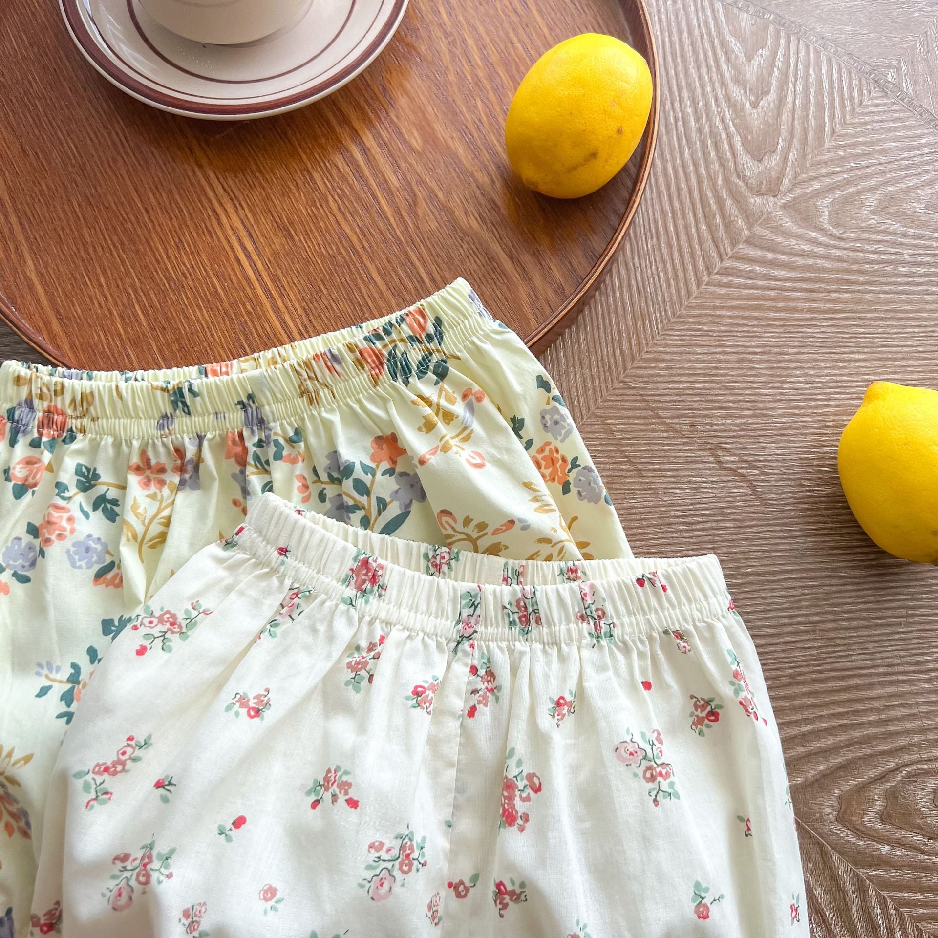 Baby girl wearing a floral print doll collar top and shorts set in white and yellow, perfect for summer outings.