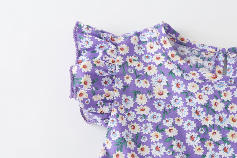 Baby girl wearing a floral print onesie with a matching headband, perfect for summer outings.