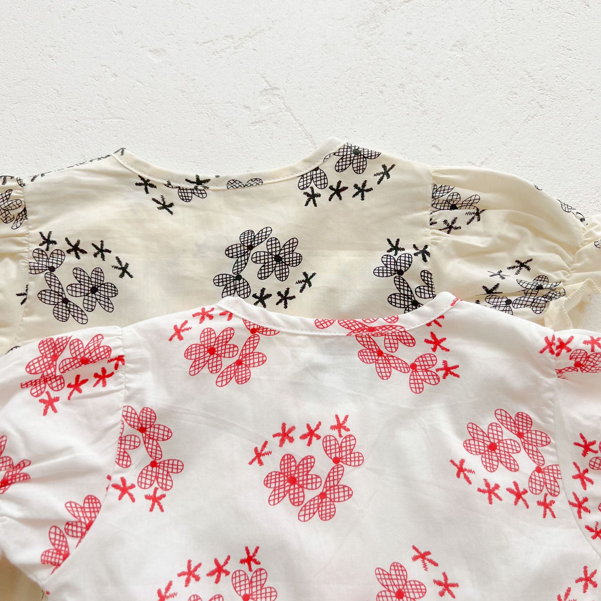 Baby girl floral print onesies with round collar and buttons in black and red colors, perfect for summer wear.