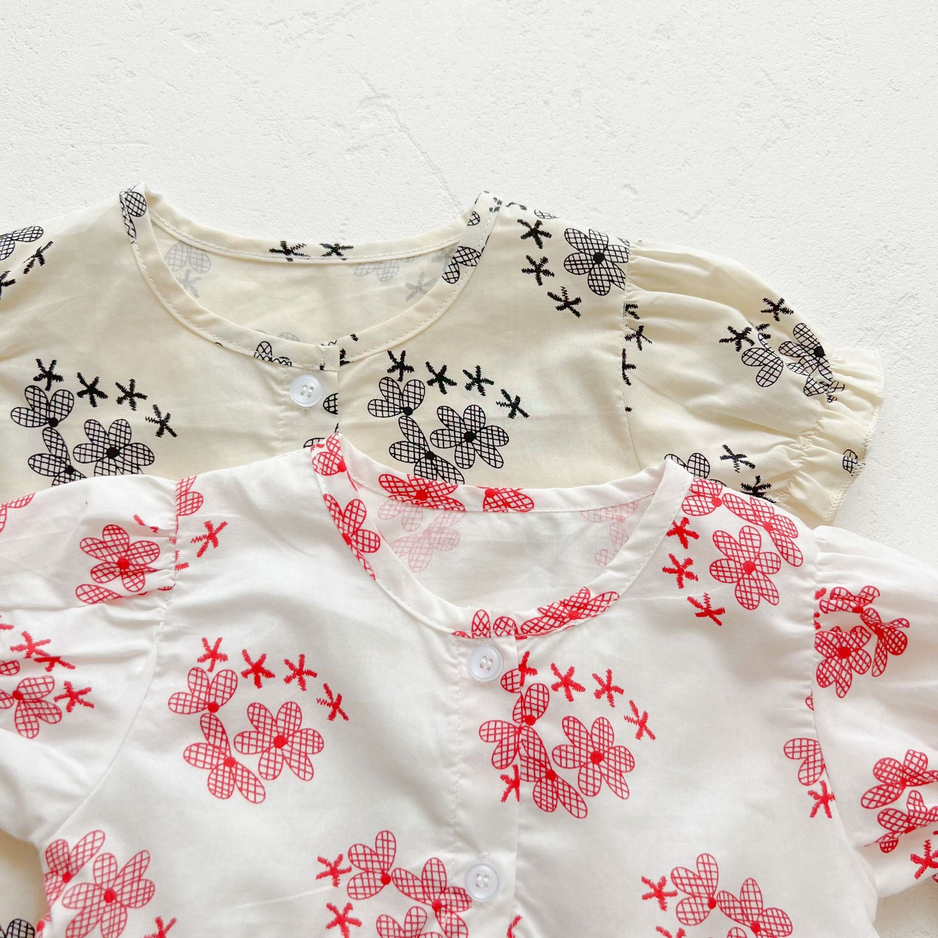 Baby girl floral print onesies with round collar and buttons in black and red colors, perfect for summer wear.