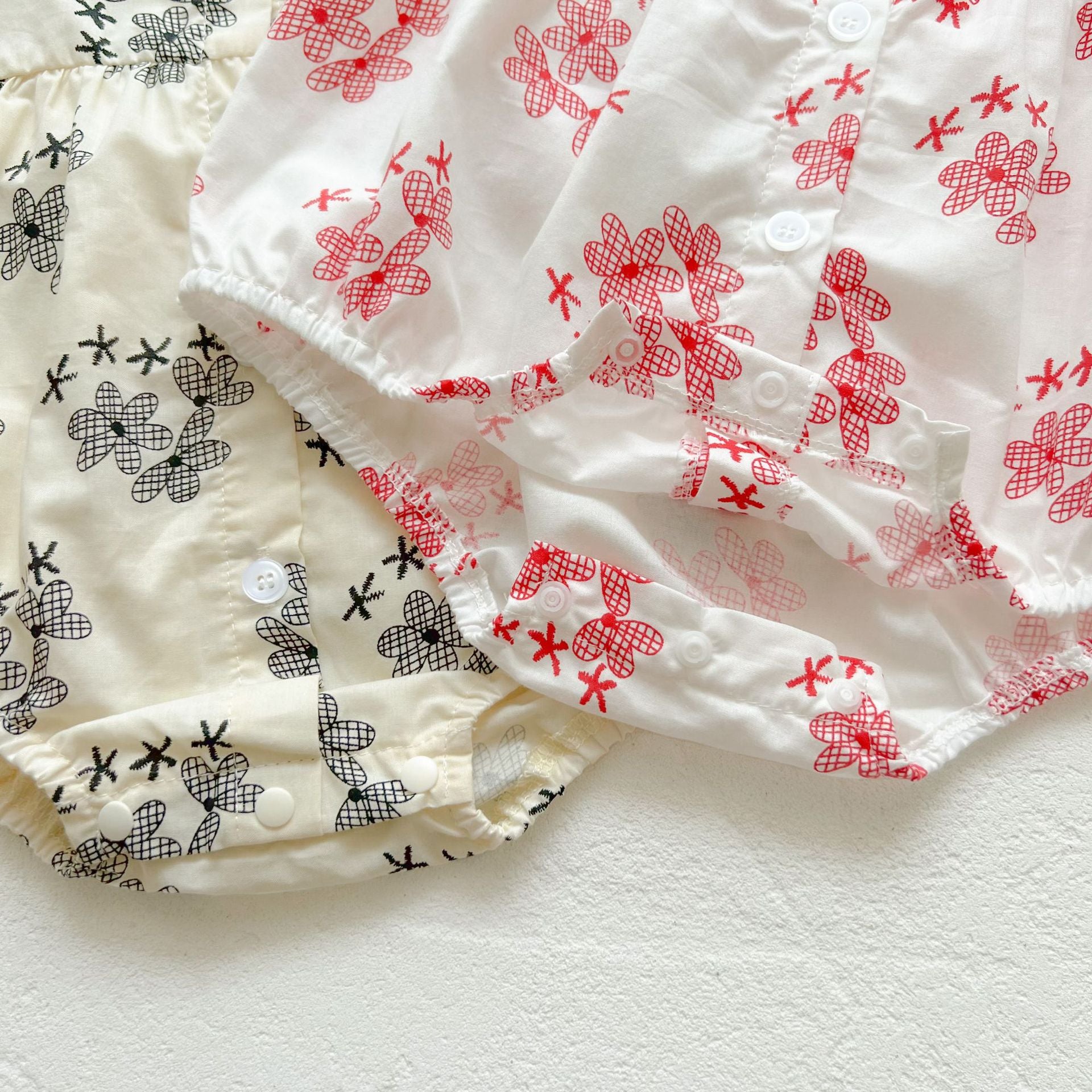 Baby girl floral print onesies with round collar and buttons in black and red colors, perfect for summer wear.