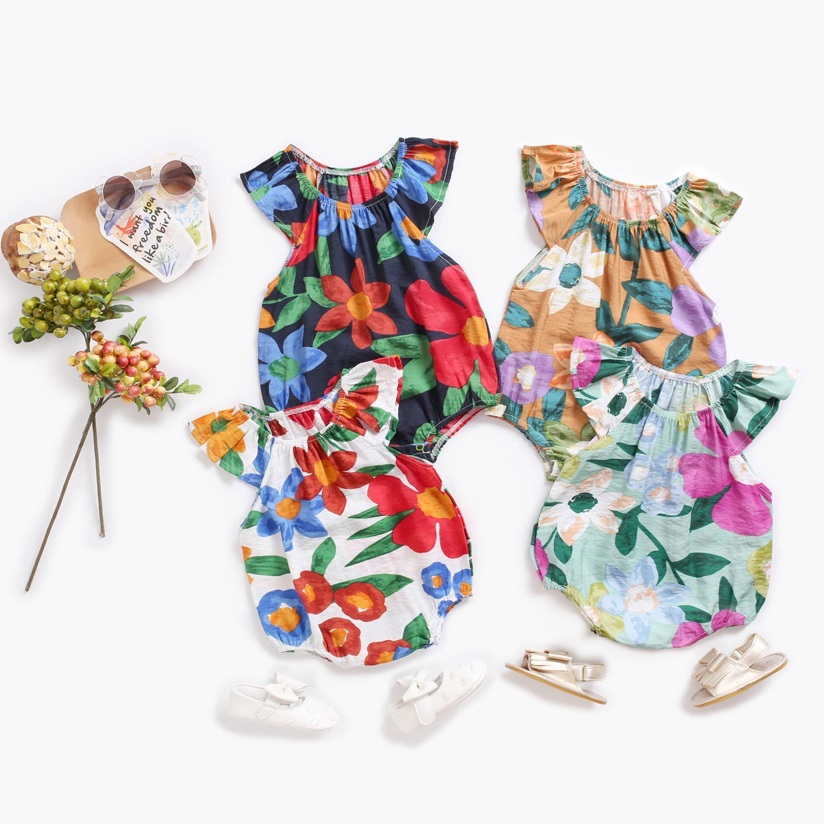 Baby girl wearing a floral print ruffle onesie, showcasing a vibrant design perfect for summer outings.