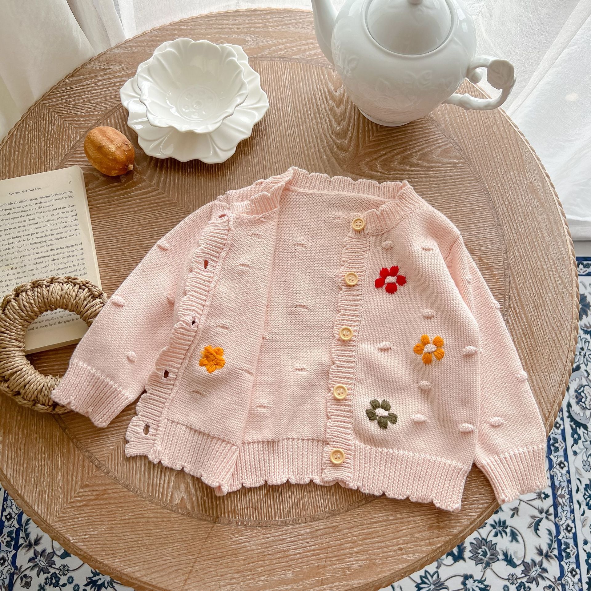 Baby girl cardigan featuring flower embroidery in white and pink colors, designed for comfort and style.