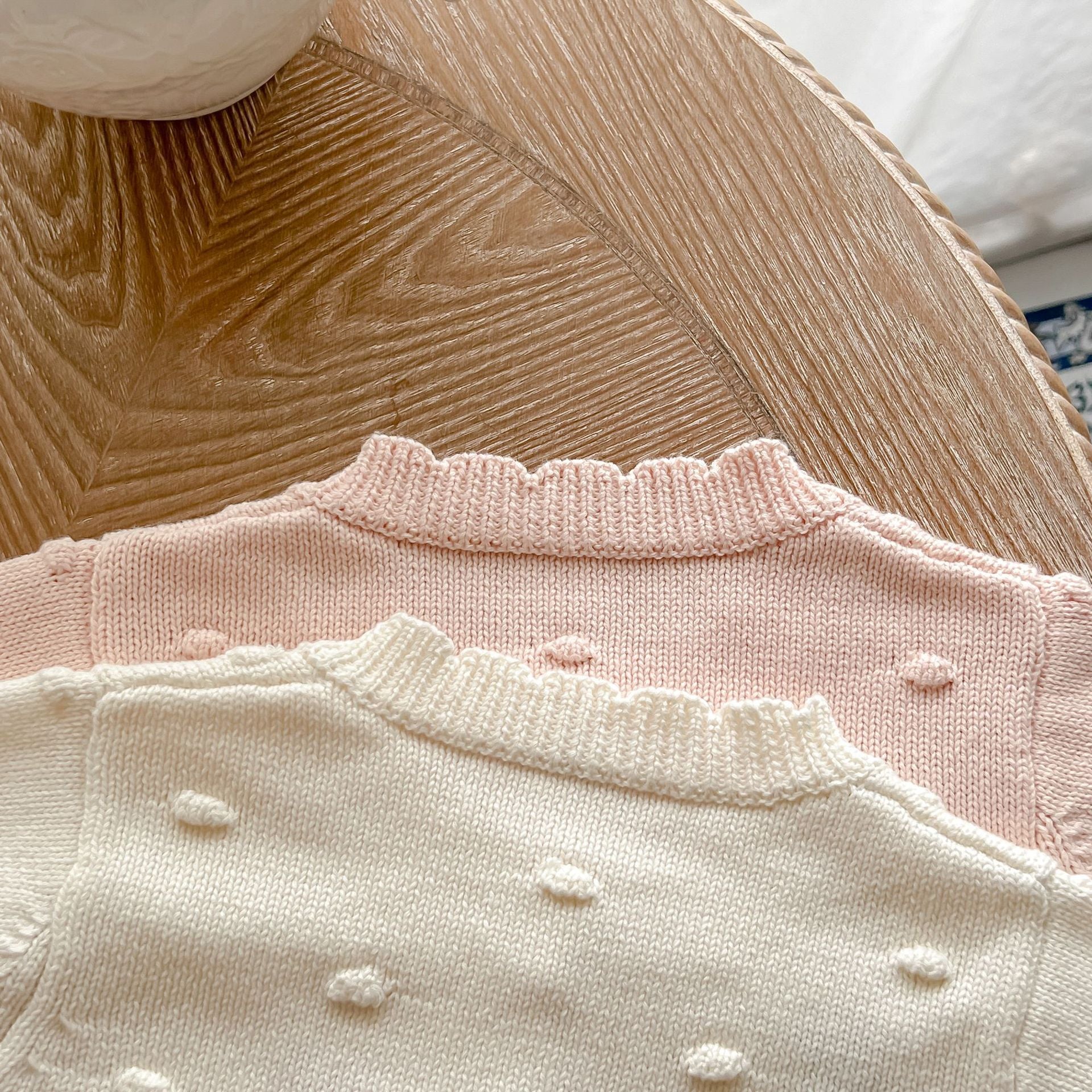 Baby girl cardigan featuring flower embroidery in white and pink colors, designed for comfort and style.