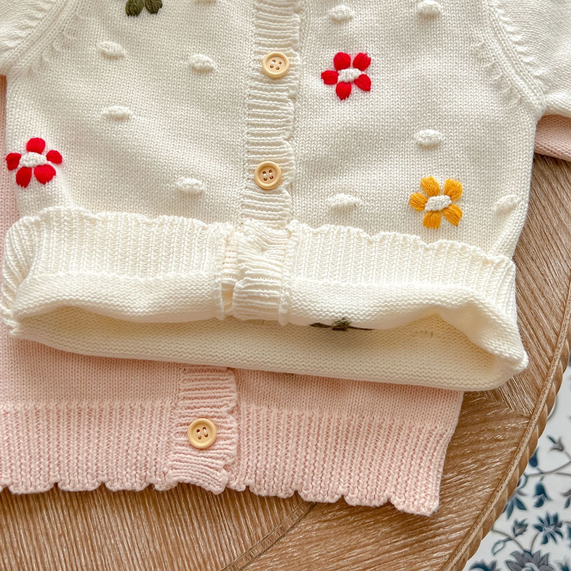 Baby girl cardigan featuring flower embroidery in white and pink colors, designed for comfort and style.