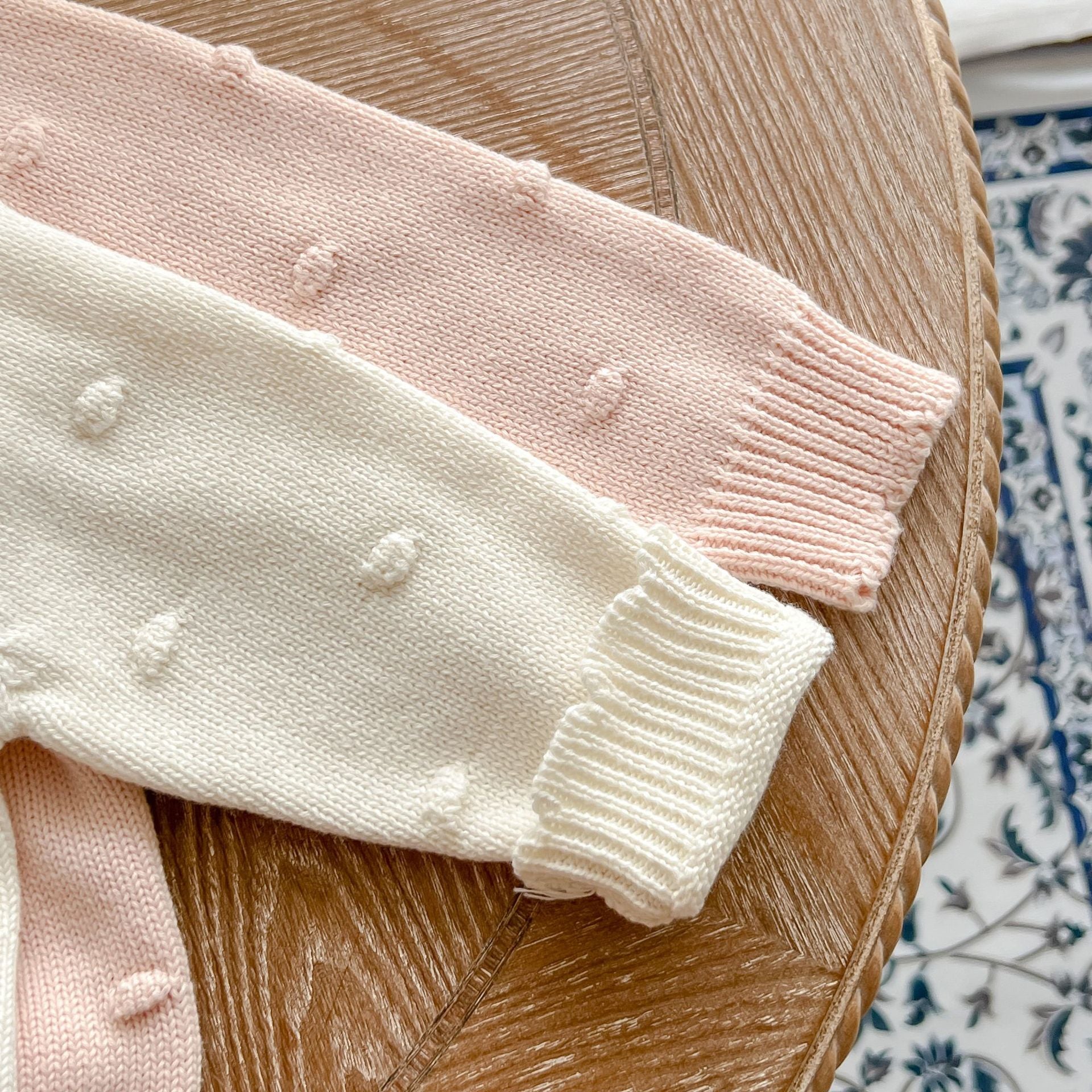 Baby girl cardigan featuring flower embroidery in white and pink colors, designed for comfort and style.