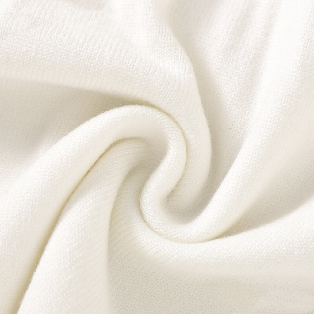 A baby girl wearing a soft knitted dress with flower patches in various colors, showcasing comfort and style.