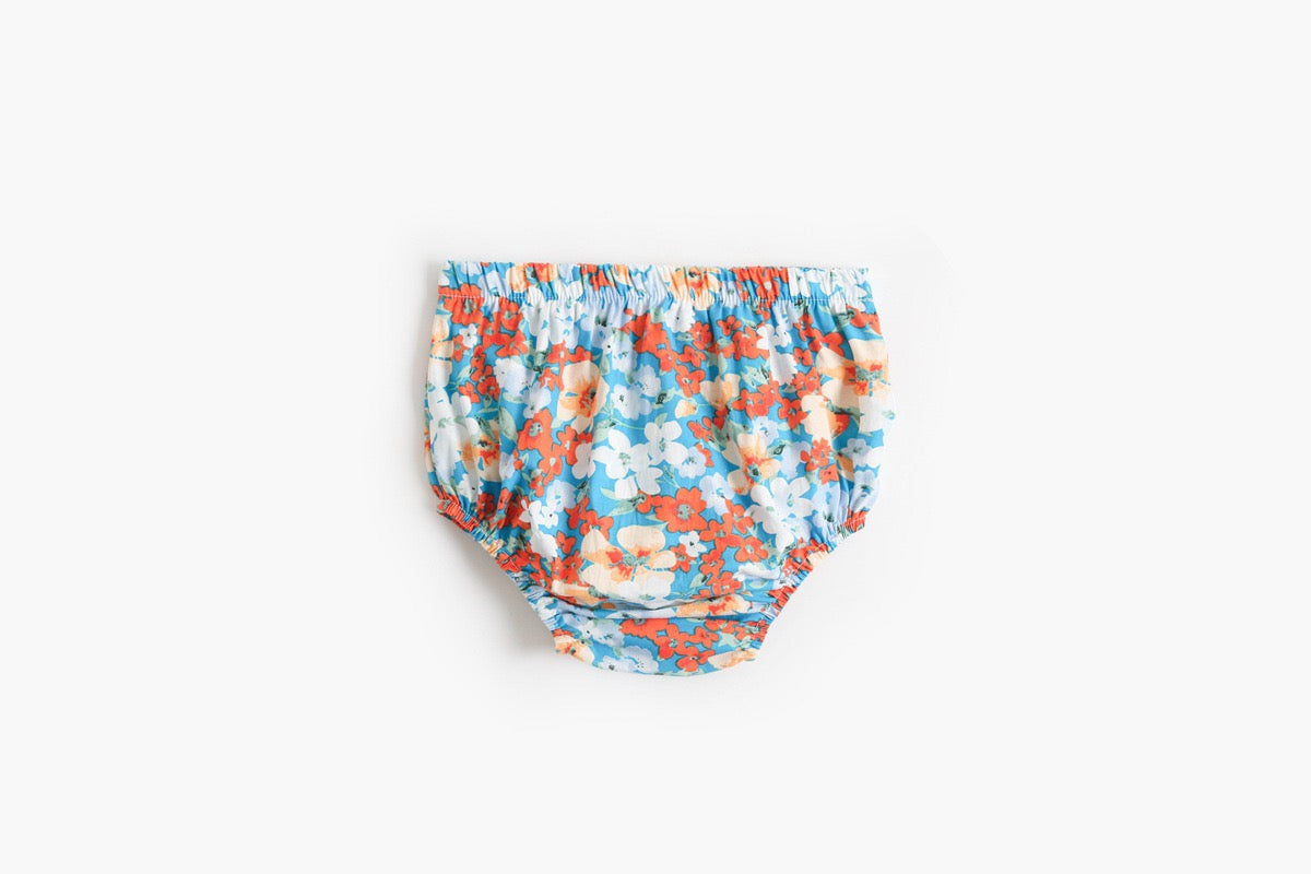 Baby girl outfit featuring a floral pattern sling top and matching shorts in pink, blue, and yellow colors.