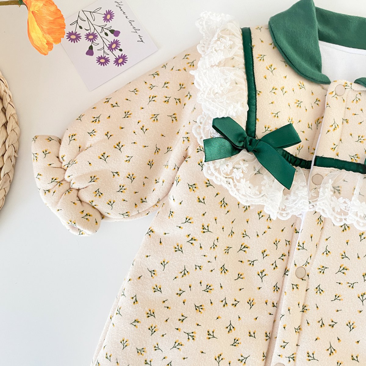 Baby girl romper featuring floral print and fleece patchwork design, perfect for winter wear.