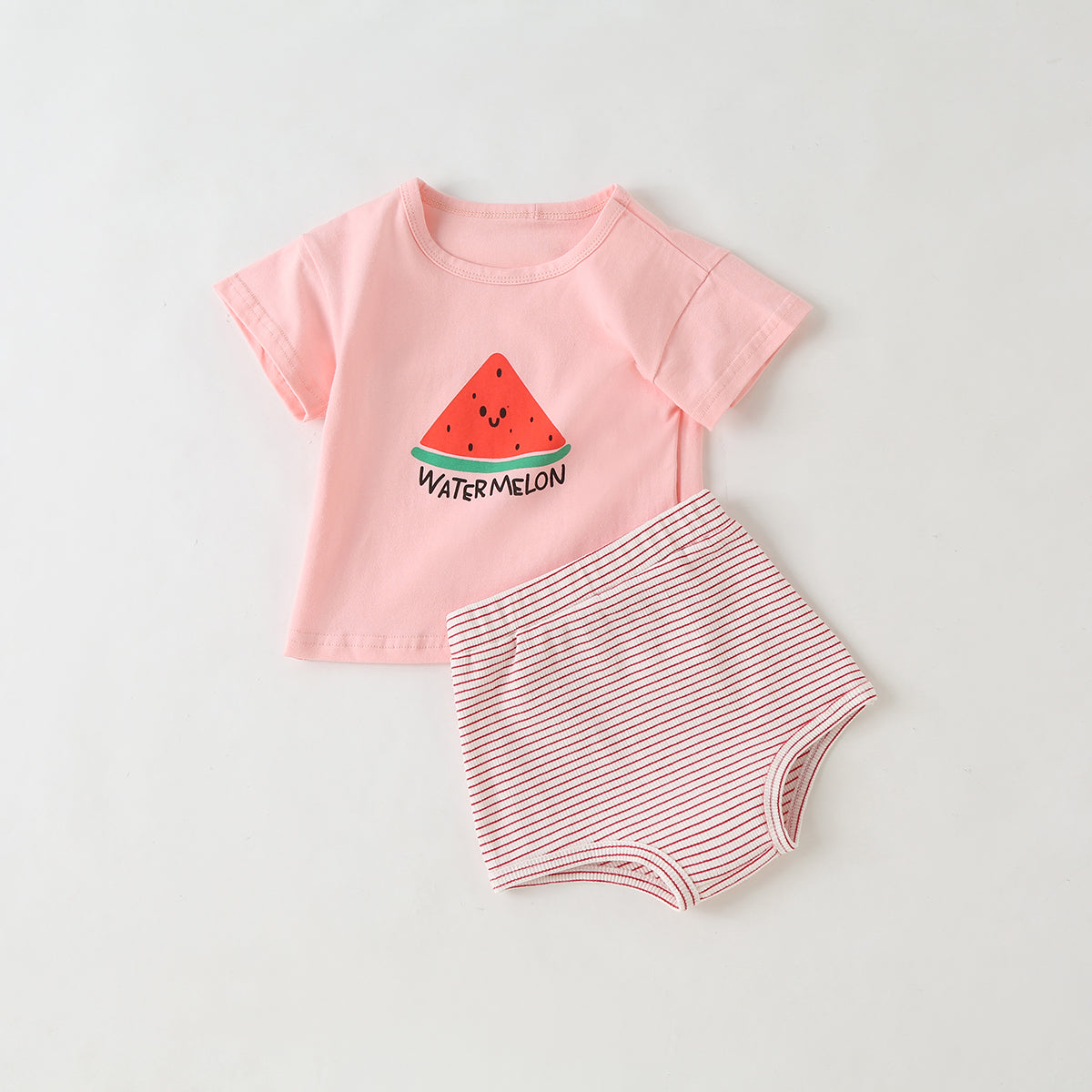 Baby girl wearing a colorful fruit pattern short sleeve top and striped graphic shorts, perfect for summer outings.