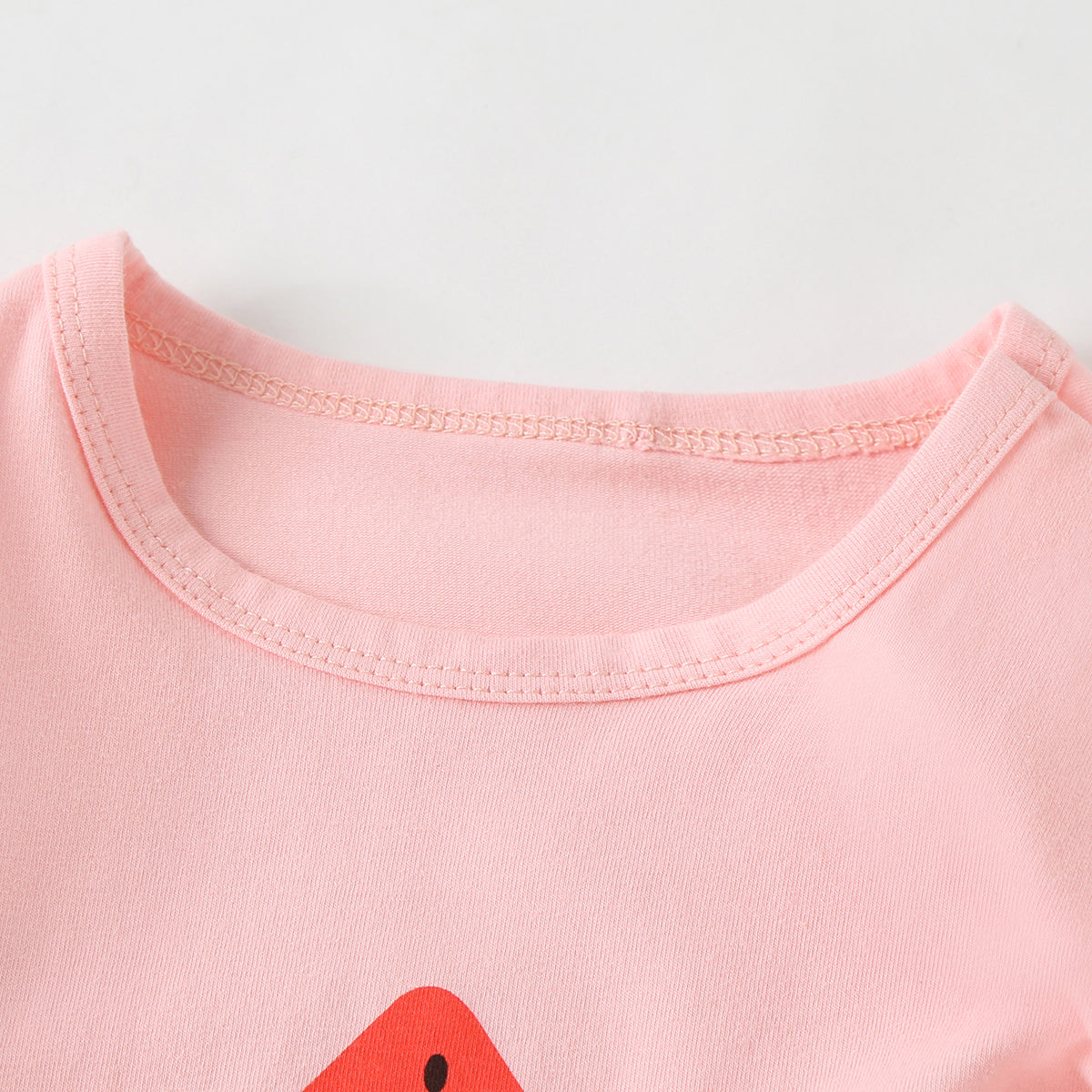 Baby girl wearing a colorful fruit pattern short sleeve top and striped graphic shorts, perfect for summer outings.