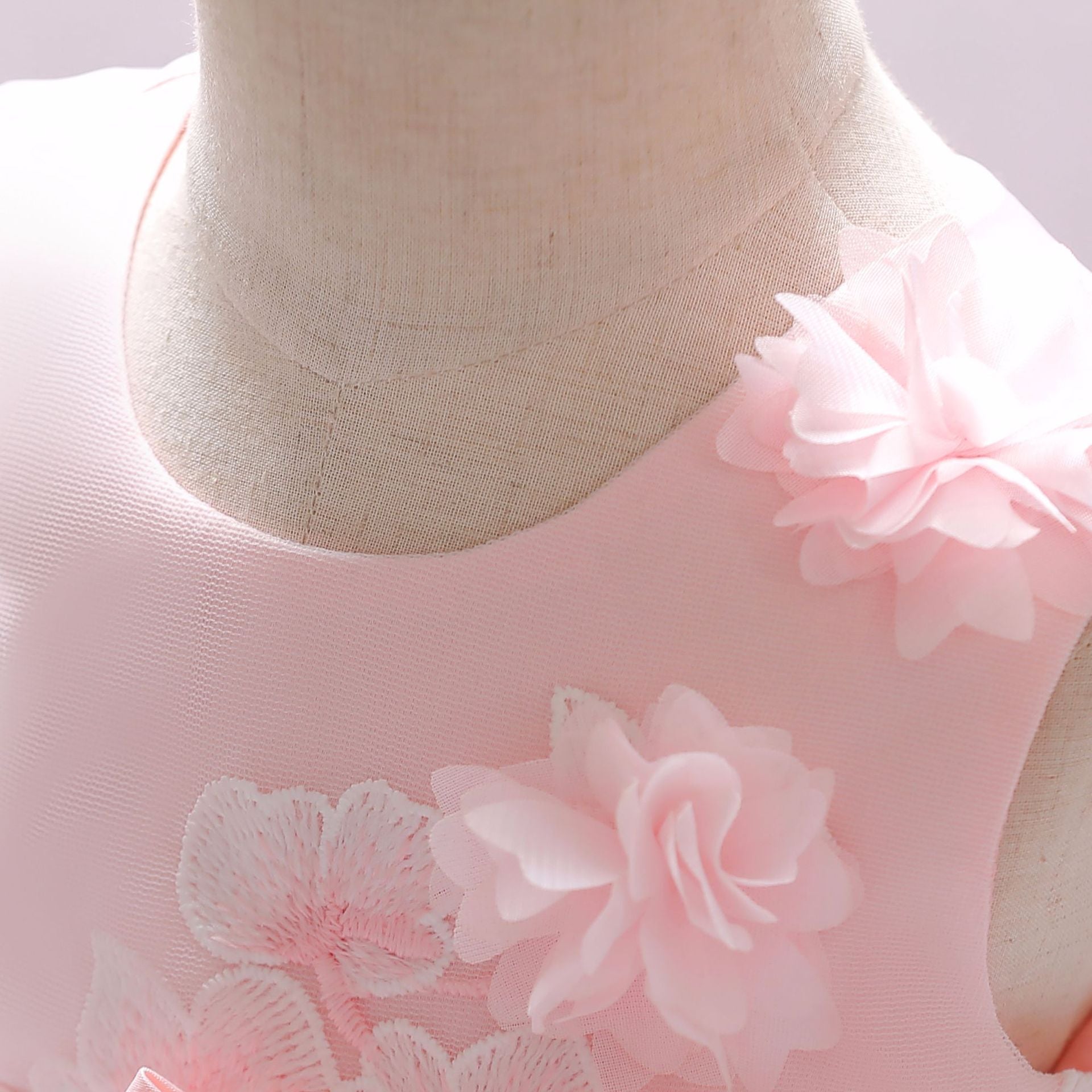 Baby girl wearing a Full Moon Christening Trailing Tutu Formal Dress in white, showcasing delicate tulle fabric and a graceful trailing skirt.