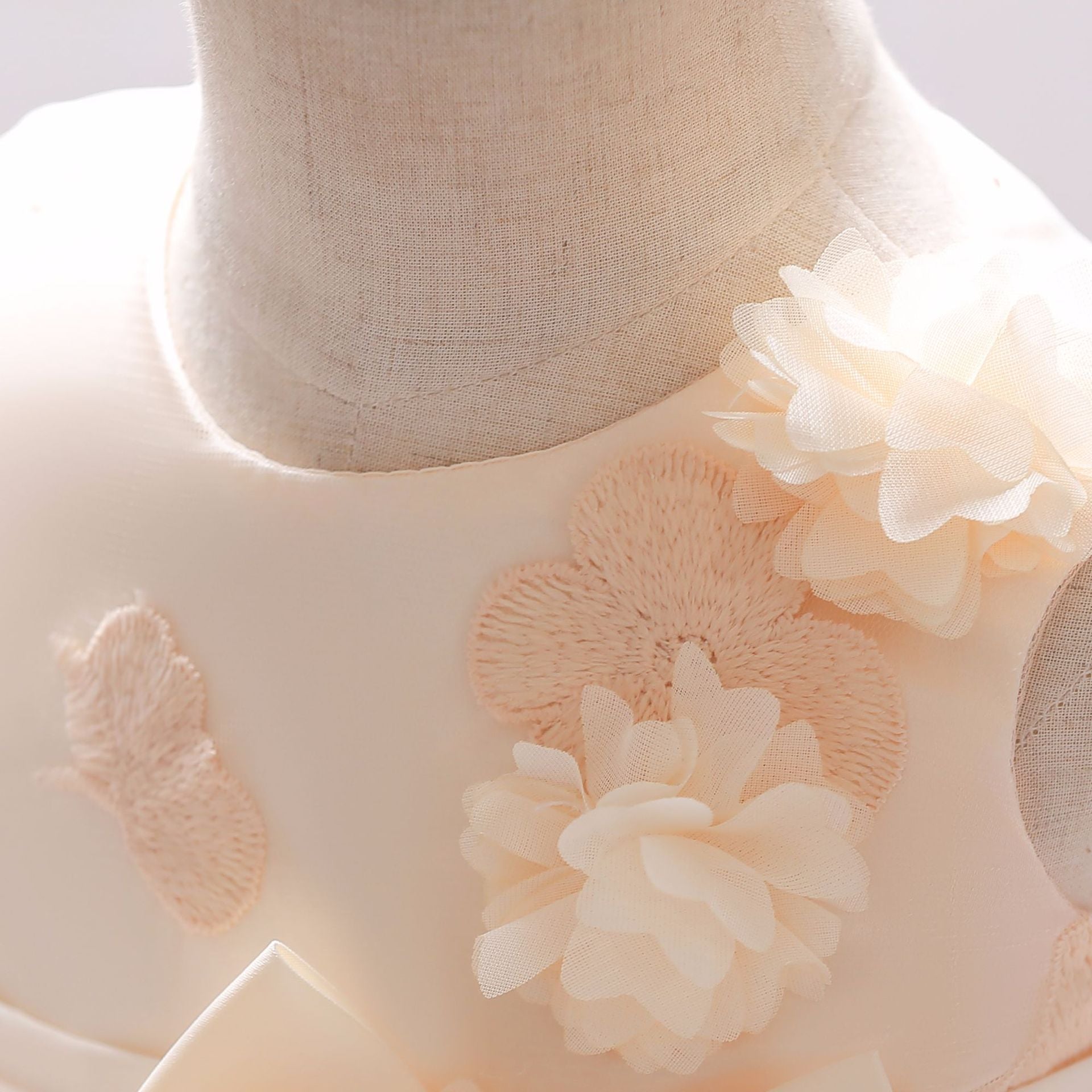 Baby girl wearing a Full Moon Christening Trailing Tutu Formal Dress in white, showcasing delicate tulle fabric and a graceful trailing skirt.