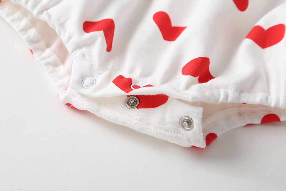 Baby girl onesie featuring a heart pattern and big bow tie, designed for comfort and style.