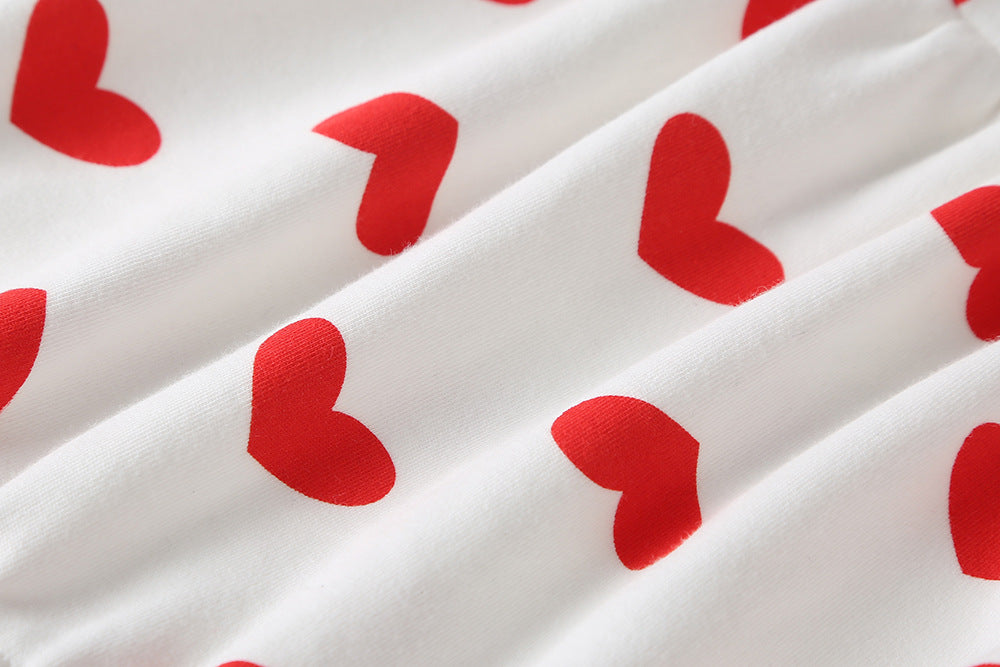 Baby girl onesie featuring a heart pattern and big bow tie, designed for comfort and style.