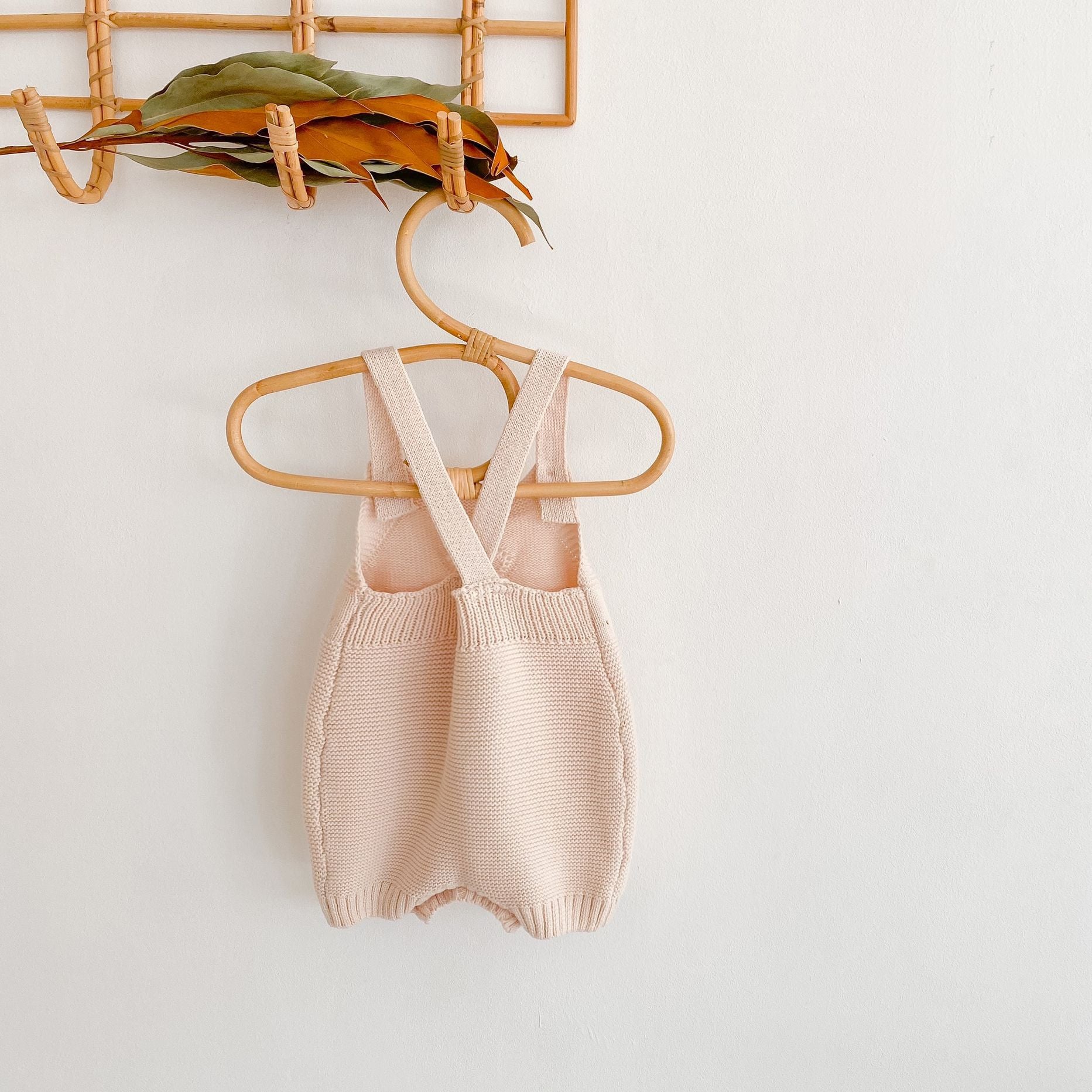 Baby girl knitted onesie in pink with ruffle design and contrast pattern, perfect for spring and autumn wear.