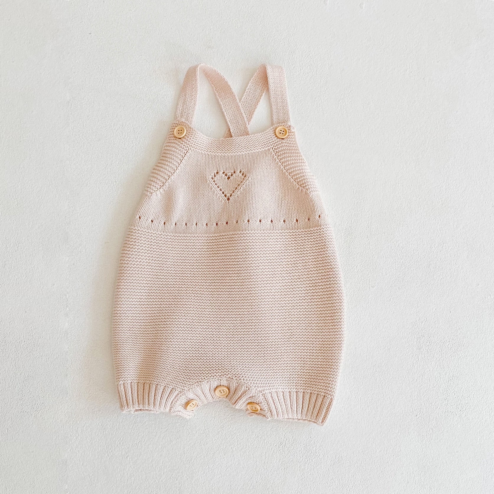 Baby girl knitted onesie in pink with ruffle design and contrast pattern, perfect for spring and autumn wear.