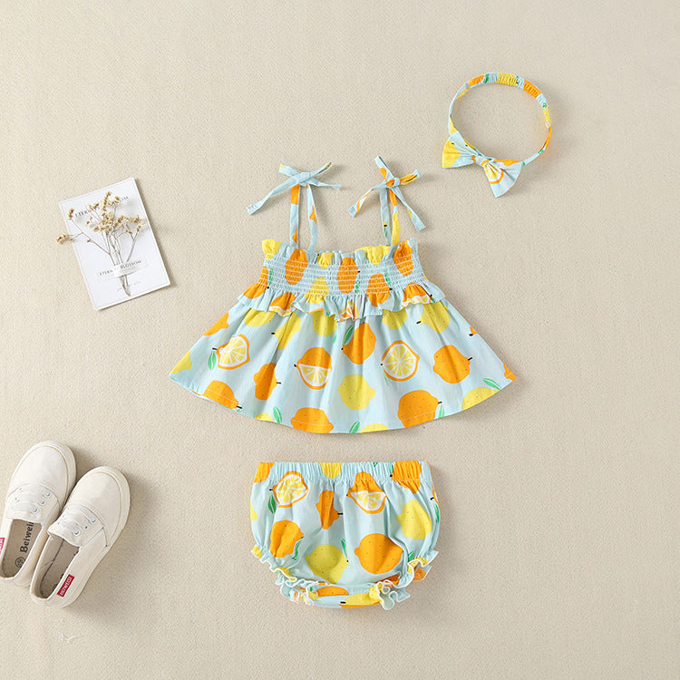 Baby girl wearing a lemon fruit print sleeveless dress combo with short pants, showcasing vibrant colors and a playful design.
