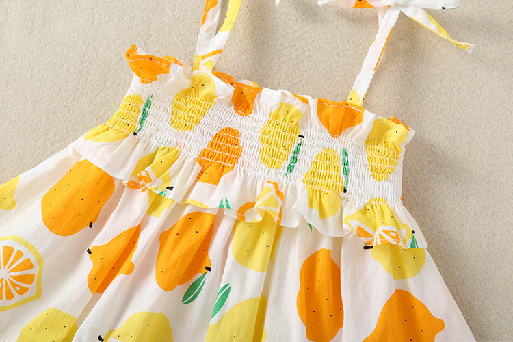 Baby girl wearing a lemon fruit print sleeveless dress combo with short pants, showcasing vibrant colors and a playful design.