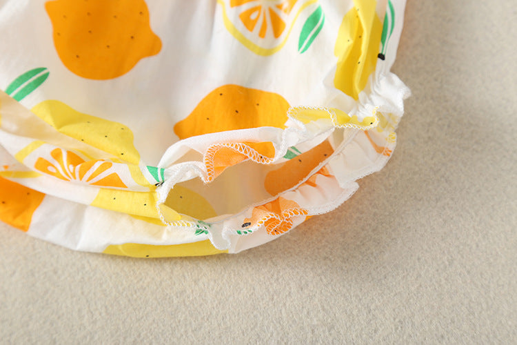 Baby girl wearing a lemon fruit print sleeveless dress combo with short pants, showcasing vibrant colors and a playful design.