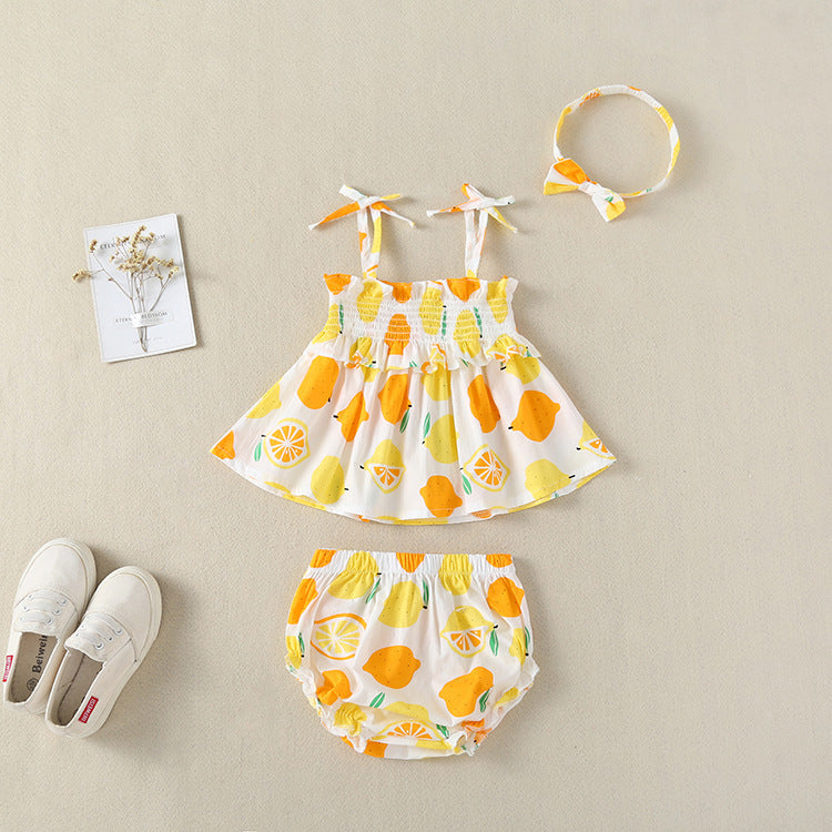 Baby girl wearing a lemon fruit print sleeveless dress combo with short pants, showcasing vibrant colors and a playful design.