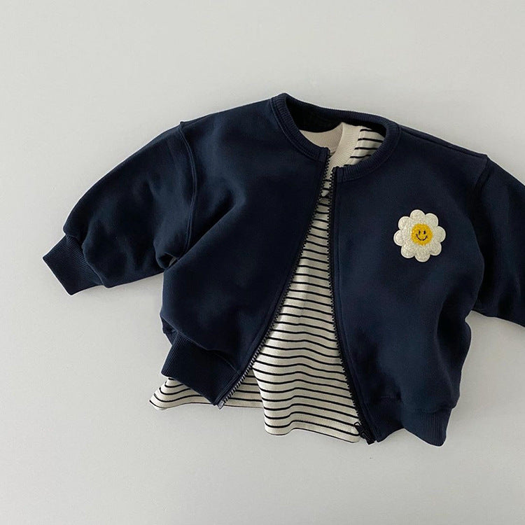 A cute baby girl wearing a cotton coat with sunflower patches and a zipper front design, perfect for autumn and winter.
