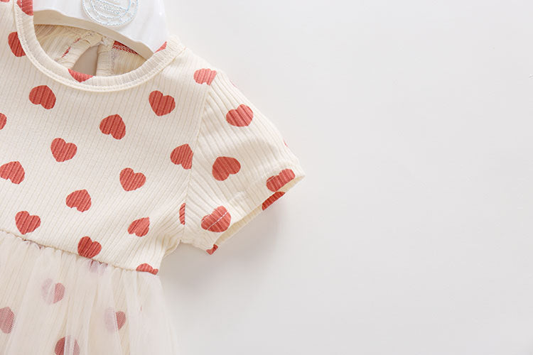 Baby girl onesie dress featuring mesh patchwork design and small heart print pattern in beige color.