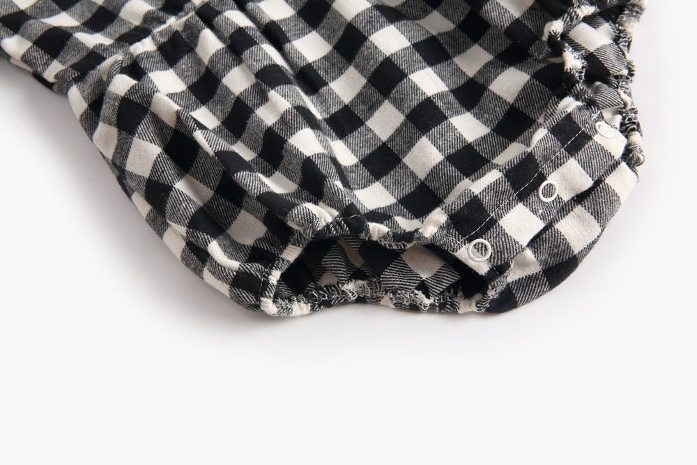 Baby girl long sleeve onesie featuring a plaid pattern and doll collar design in black and grey colors.